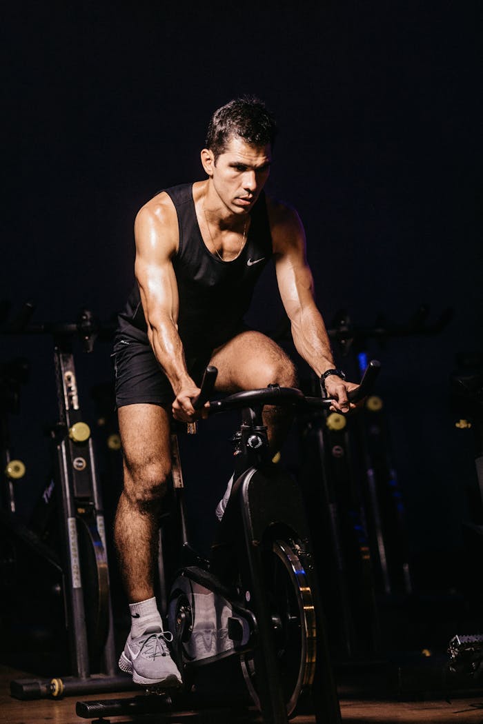 services-01 A determined male athlete engaged in an intense indoor cycling session. Perfect for fitness-themed designs.