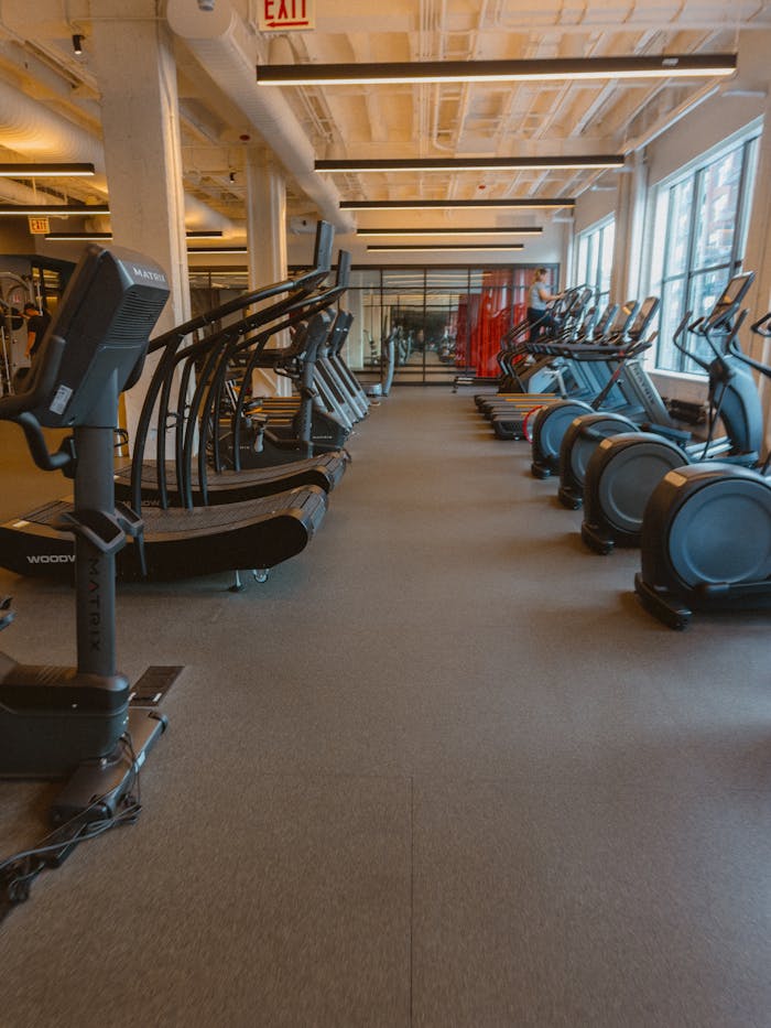 services-04 Spacious fitness center featuring treadmills, ellipticals, and exercise bikes for a complete workout.